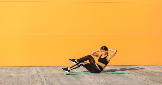 a female athlete is exercising in front of a yellow wall