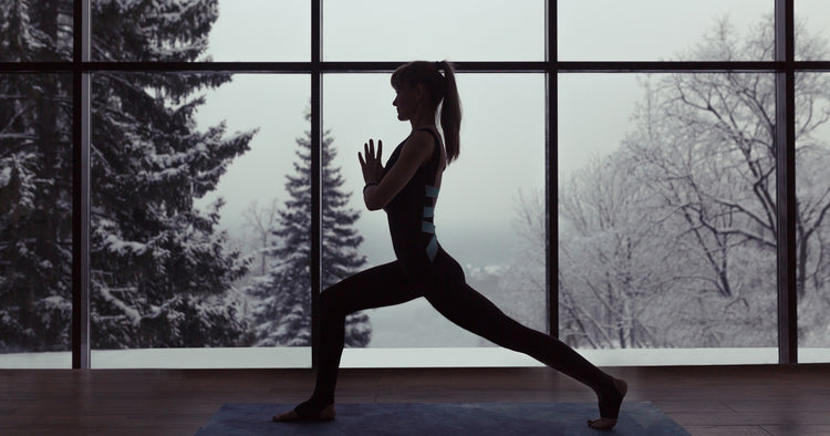 a lady is doing yoga in living room in winter