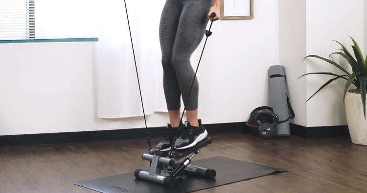 a woman is working out on stepper with bands
