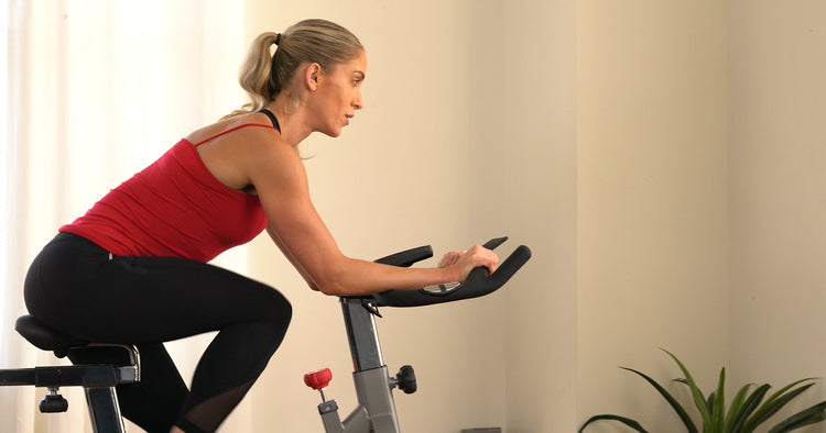 a woman is cycling indoor