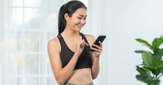 Woman using and smiling at her phone