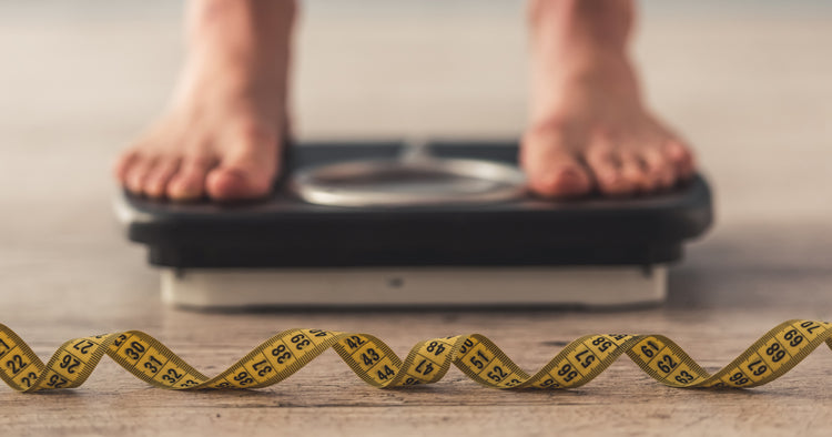 a person is standing on weight scale with a measuring tape in the front