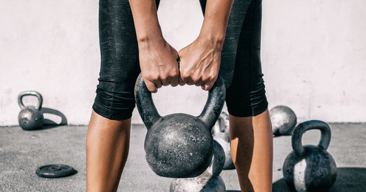 a woman is lifting kettlebell