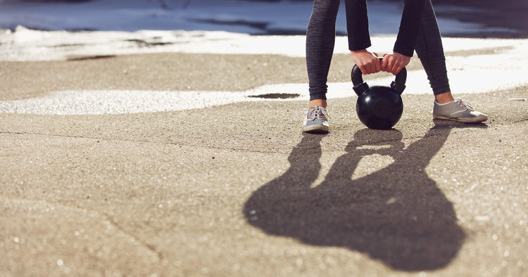 a person is holding a kettlebell
