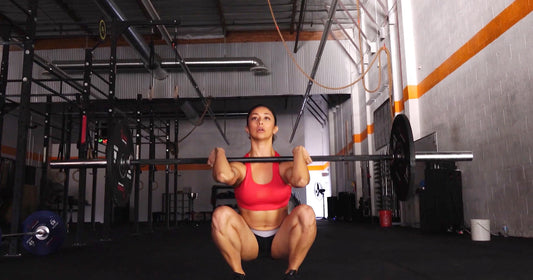 A woman is lifting Olympic Bar