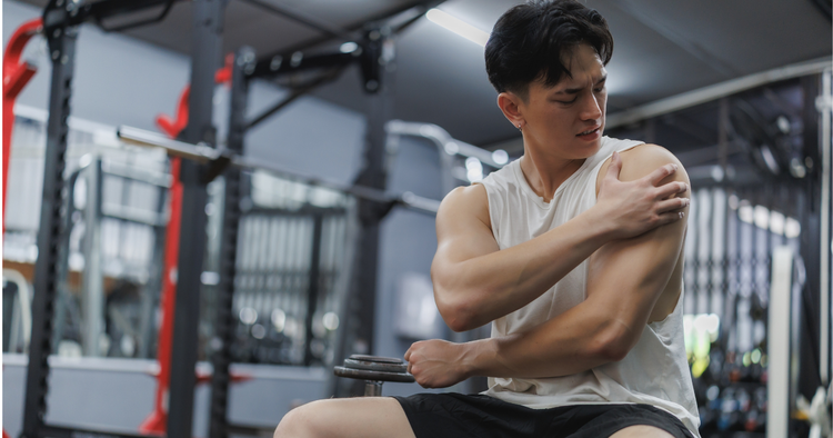 Athlete feeling his shoulder after weight training
