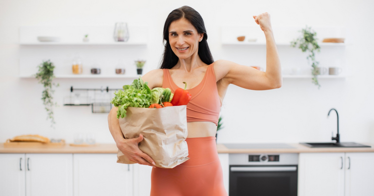 Woman showing her arm muscles while carrying a bag of groceries. 