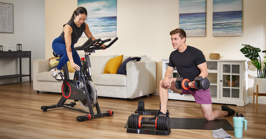 couple working out indoors using Sunny Health & Fitness cycle bike and adjustable dumbbells for 20-minute workouts