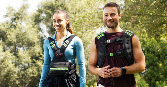 Couple walking while wearing a weighted vest outside.