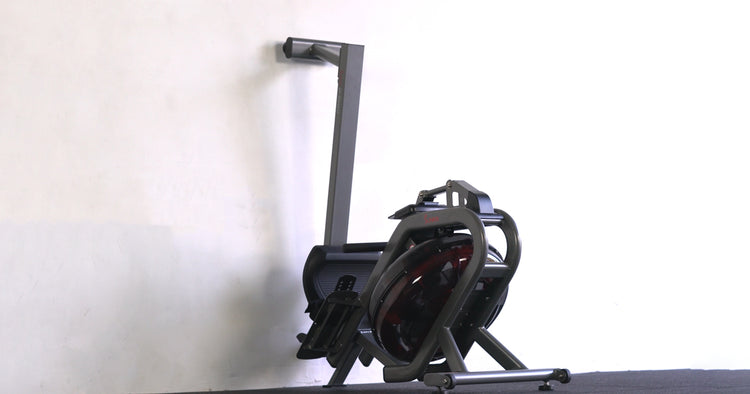 water rower folded and standing against a wall