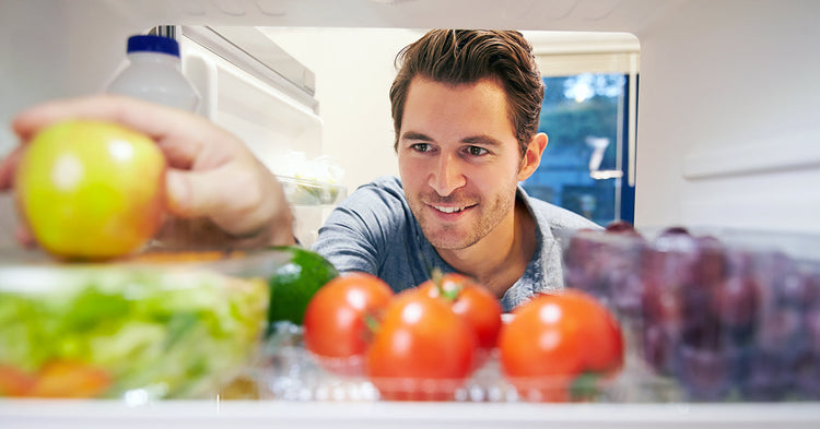 Man considering the healthy ingredients to keep in the fridge