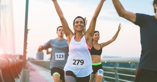 woman cheers as she runs marathon