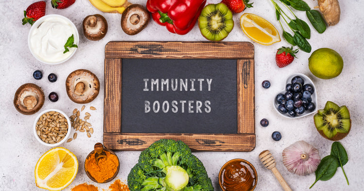 a board writing IMMUNITY BOOSTER is surrounded with variety of vegetables and fruits
