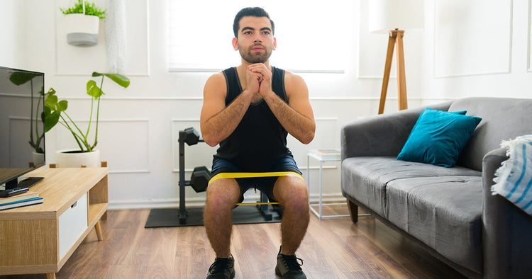 Man in home gym working out with resistance bands