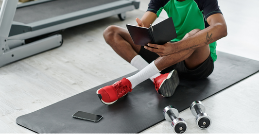 Man sitting on yoga mat while journaling.