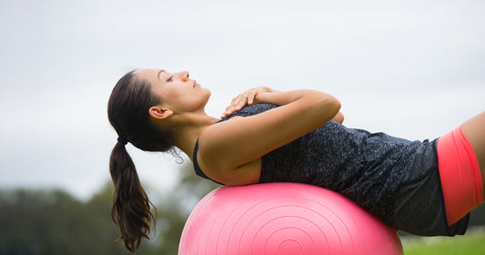 a lady is working out with an exercise ball