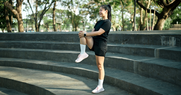 woman performs warm up routine before her workout outside