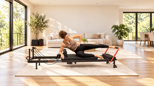 Woman performing Pilates exercise on reformer.