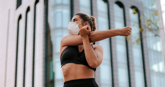 a woman wearing a mask is stretching
