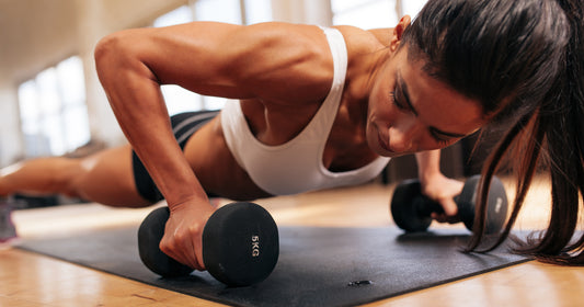 woman doing push ups exercise with dumbbells
