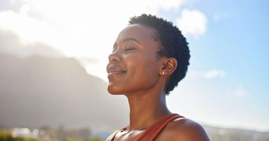 woman smiles with sun shining on her face