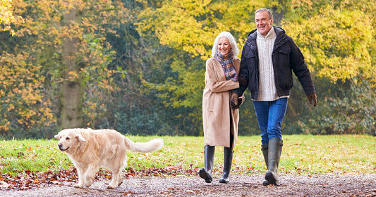 Senior couple and dog walking outdoors